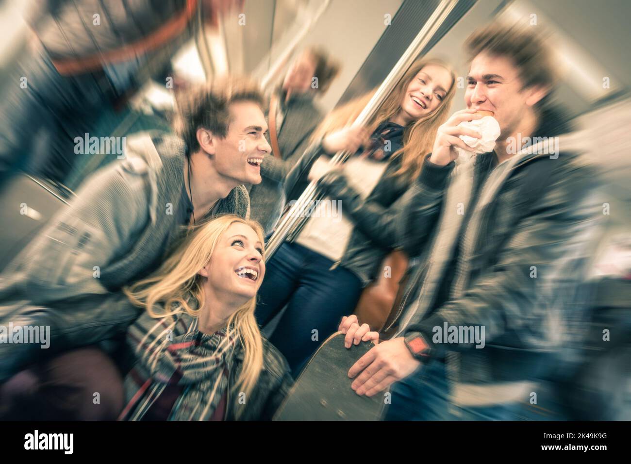 Gruppe von jungen Hipster-Freunden, die Spaß haben und im U-Bahn-Zug reden - Vintage gefilterter Look mit radialer Unschärfe - Konzept der Jugend und Stockfoto