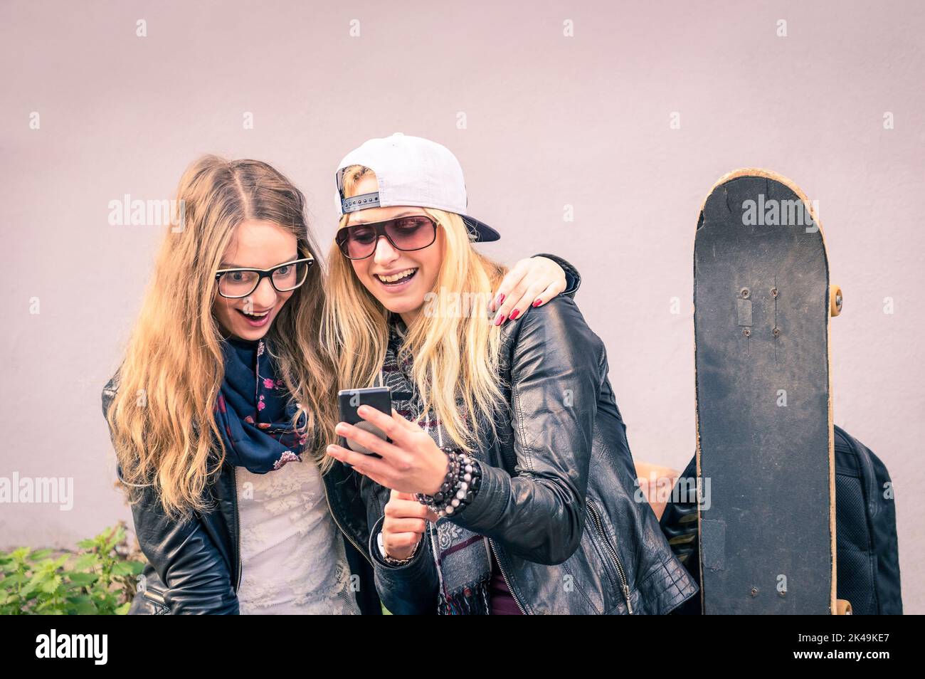 Beste Freunde, die mit dem Smartphone gemeinsam Zeit im Freien genießen - Konzept neuer Trends und Technologien mit Hipster-Freundinnen, die Spaß in der Großstadt haben Stockfoto
