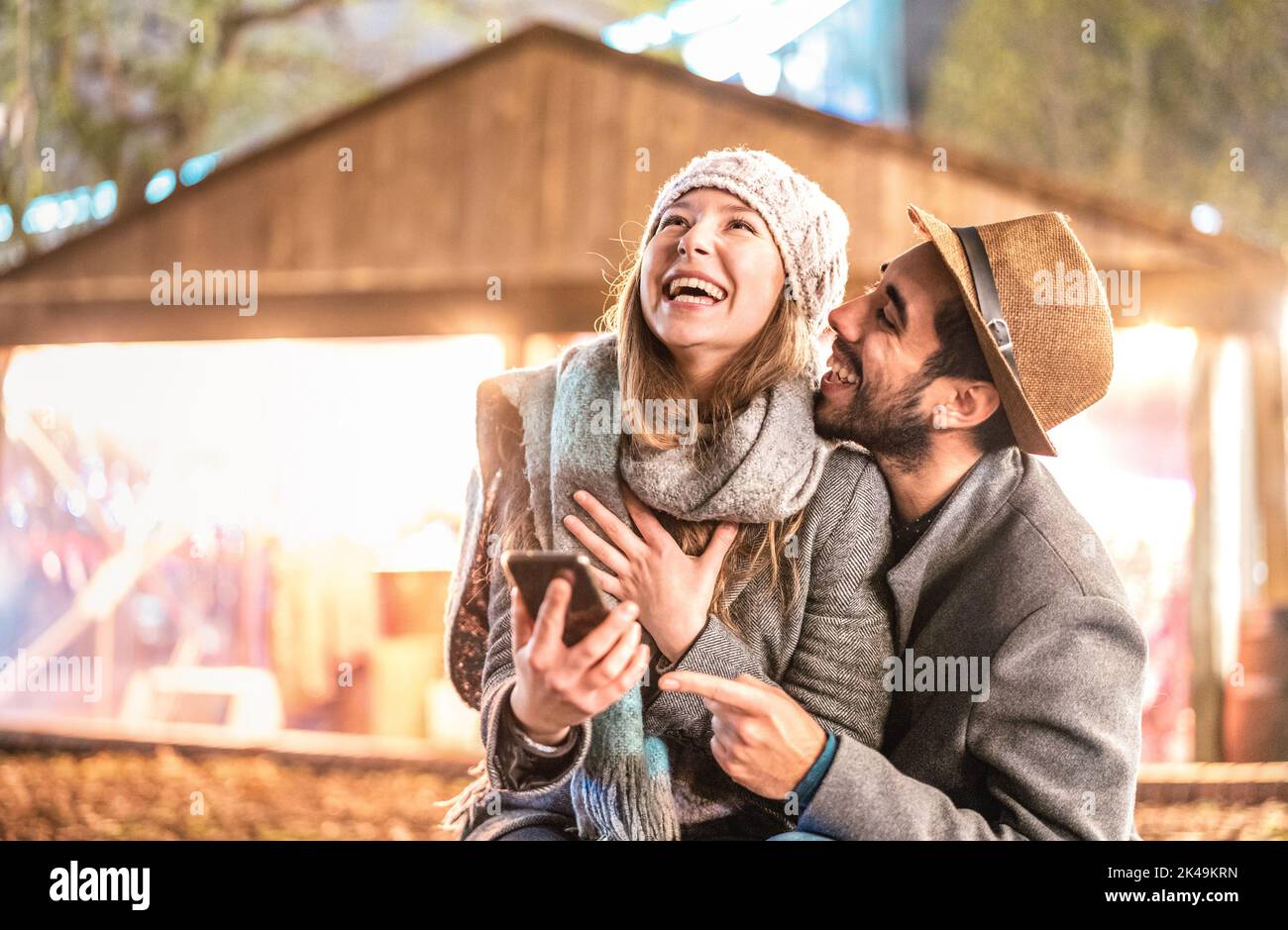 Glückliches Paar in der Liebe Spaß mit Handy im Winter - Influencer Kerl und Mädchen auf Social Media - Beziehungskonzept mit Freund Stockfoto