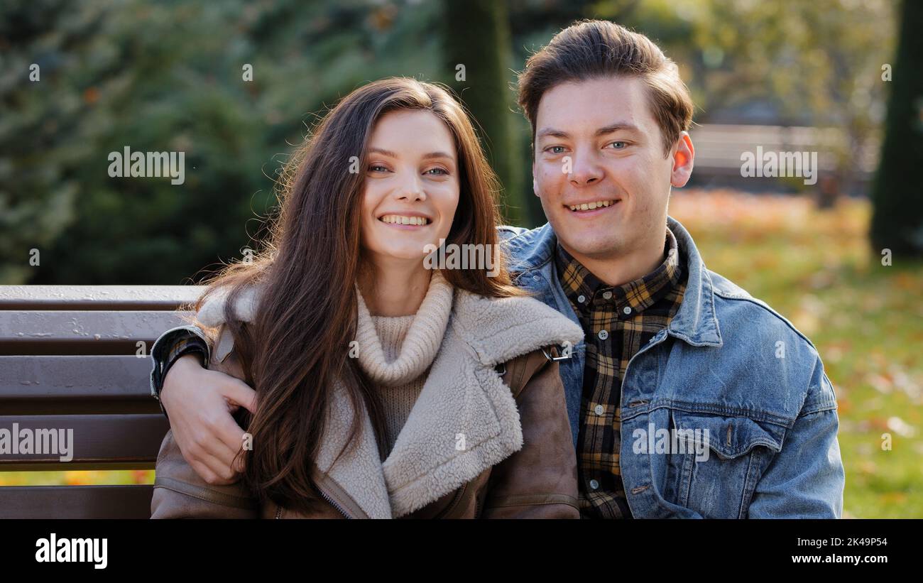 Portrait von zwei jungen Partnern Paar in romantischen Beziehungen Kaukasische Familie flirtet auf der Bank gut aussehender Kerl küsst wunderschöne brünette Frau Stockfoto