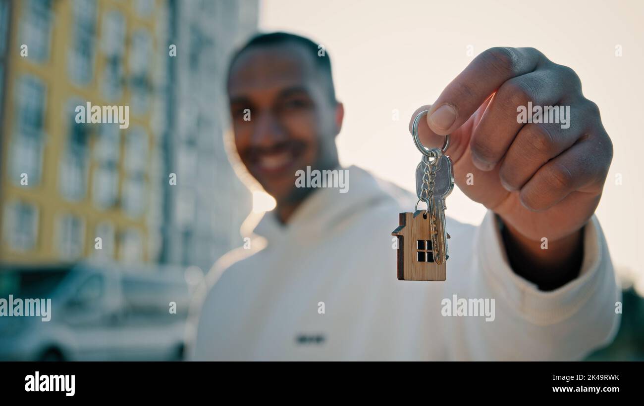 Glücklicher Hausbesitzer Immobilienmakler Latino-Mann mit einem Haufen Schlüssel, der eine Wohnung mit neuer Wohnungswohnung verkauft Werbung, die in modernen Wohnungen verkauft wird Stockfoto