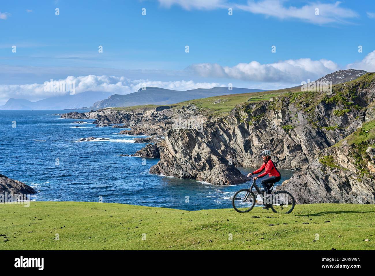 Nette ältere Frau auf dem Mountainbike, Radfahren auf den Klippen von Achill Island, Carrowgarve, Republik Irland Stockfoto