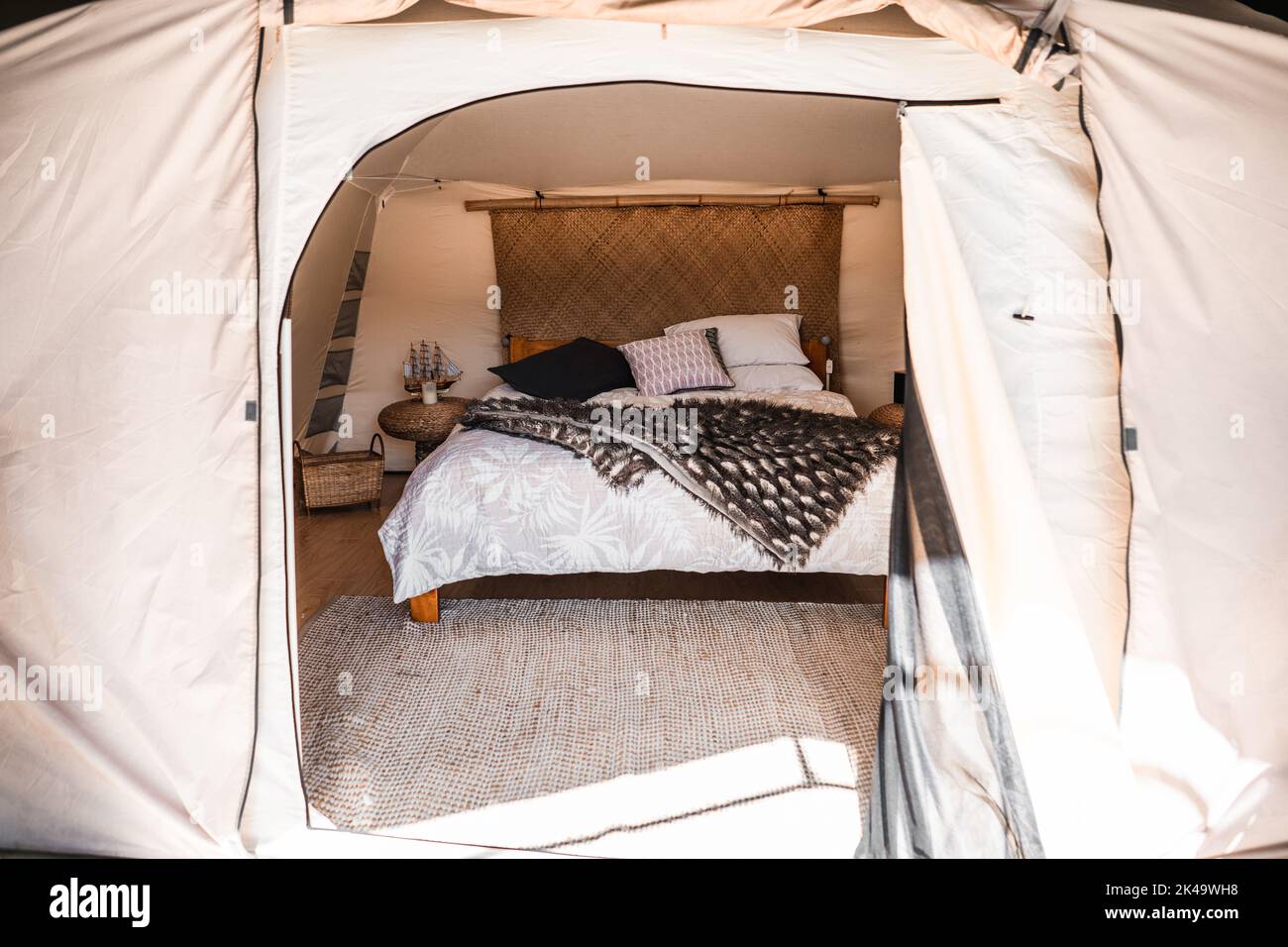 Heller und freundlicher Raum eines Zeltes, der mit einer Decke und weichen Kissen auf einem gemütlichen Teppich dekoriert ist Stockfoto