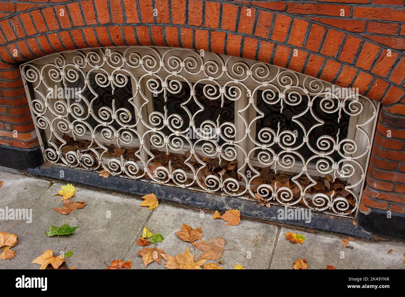 Ziergitter aus Metallarbeiten, die das Kellerfenster in der Straße in Chelsea bedecken Stockfoto