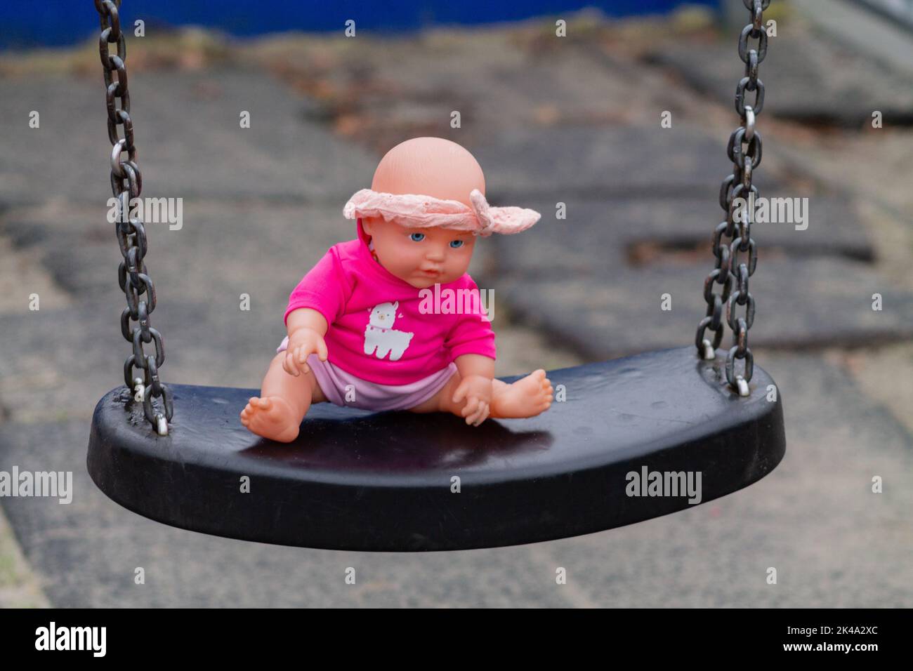 Eine Nahaufnahme einer rosa Puppe auf der Schaukel im Garten Stockfoto