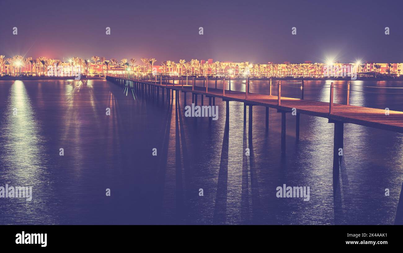 Lange hölzerne Seebrücke in der Nacht, Farbtonierung aufgetragen. Stockfoto