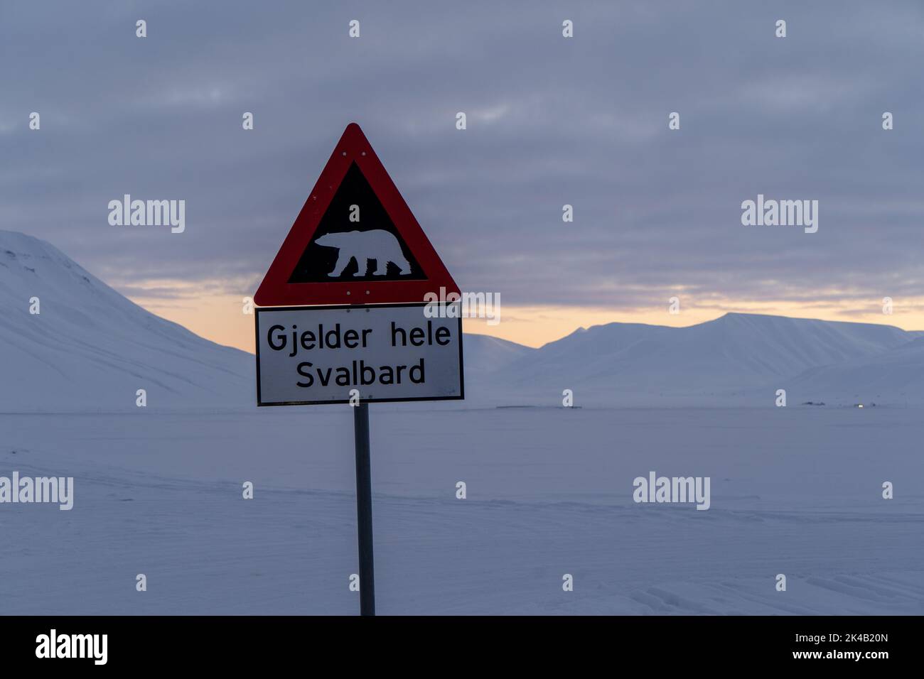 Eisbären-Warnschild außerhalb von Longyearbyen am verschneiten Wintertag bei Sonnenuntergang, Svalbard Stockfoto