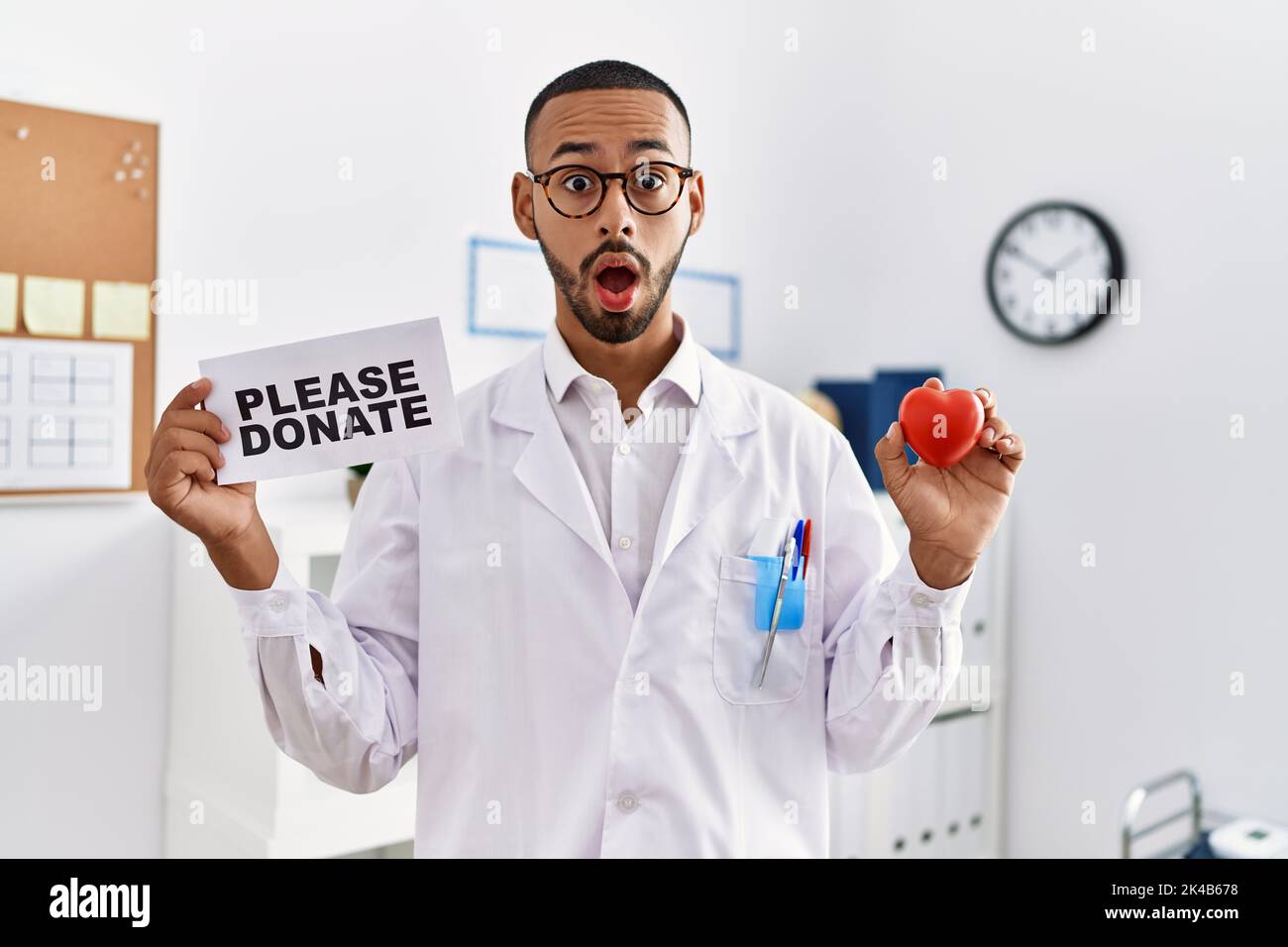 afroamerikanischer Arzt, der Organspenden im Schockgesicht unterstützt, skeptisch und sarkastisch aussagend, überrascht mit offenem Mund Stockfoto