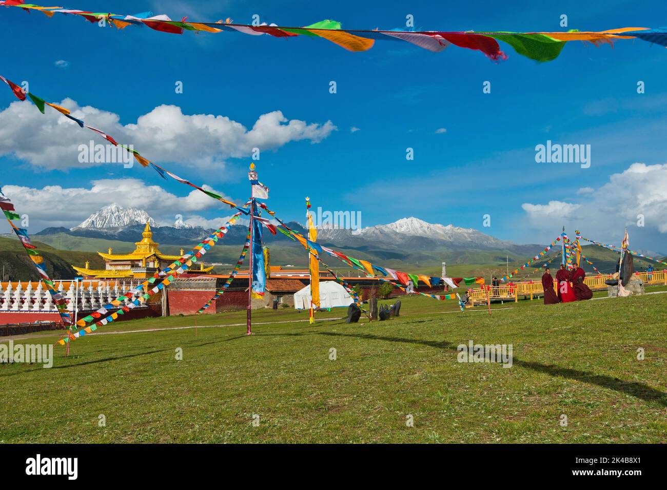 Gruppe tibetischer Mönche, die das Kloster Lhagang im Grasland von Tagong vor dem Berg Yala, 5820 m, besuchen Stockfoto