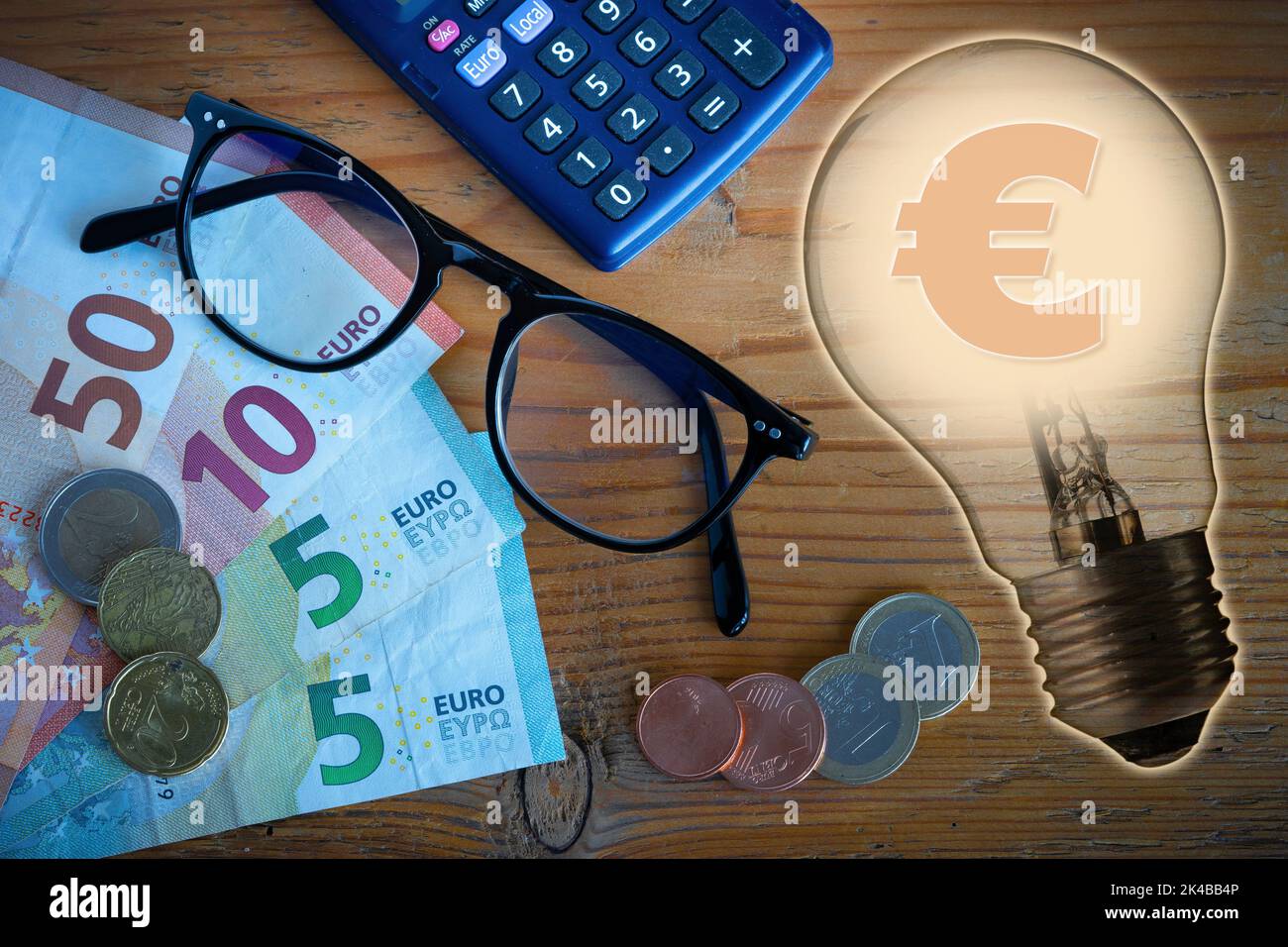Illustration zum Thema der Kosten der elektrischen Energie, mit Euro-Münzen und Banknoten Rechner und Brille und eine Glühbirne in Transparenz Stockfoto