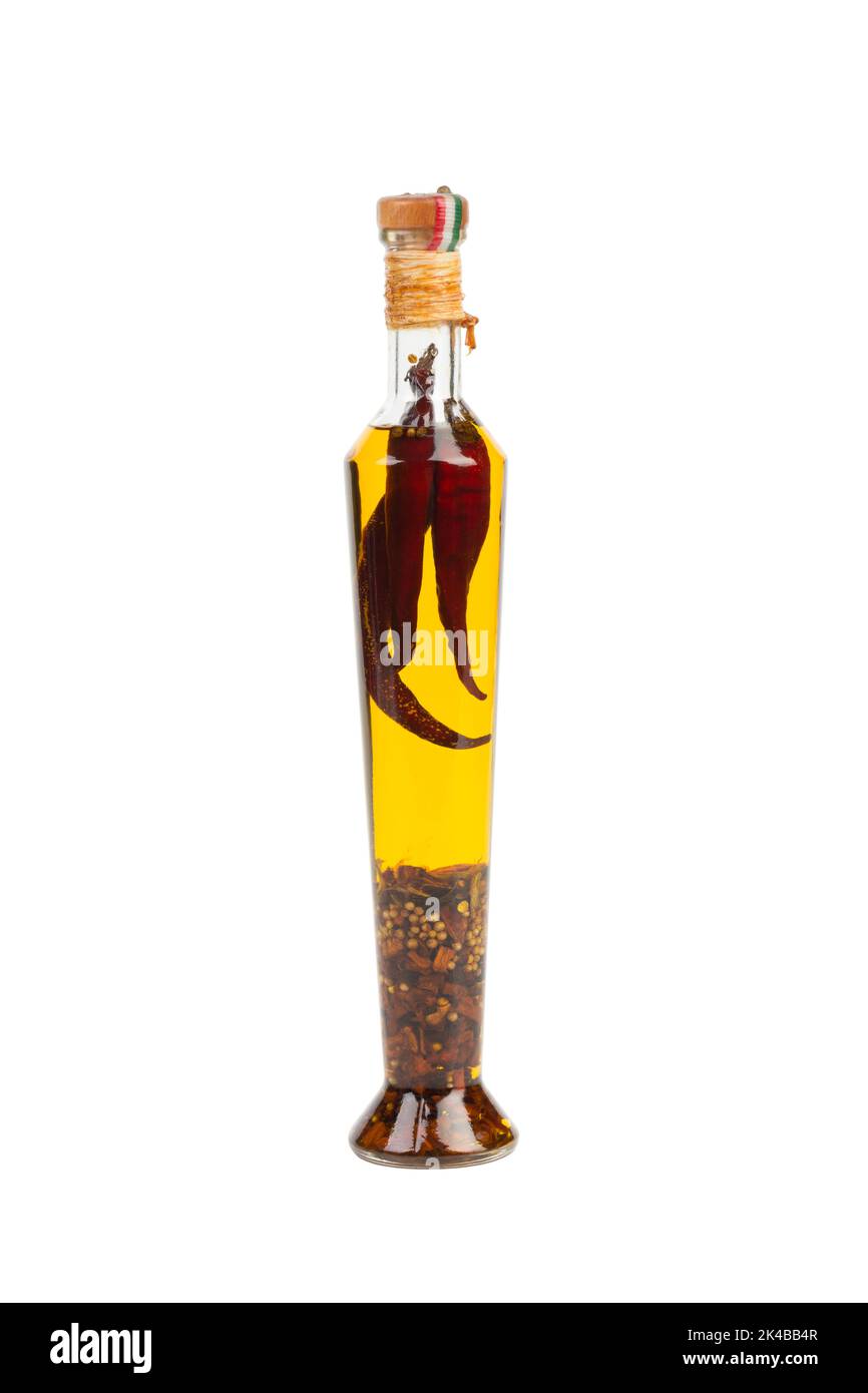 Glasflasche mit erstklassigem nativem Olivenöl mit Gewürzen und Kräutern. Isoliert auf weißem Hintergrund. Chili Olivenöl. Olivenöl mit Paprika oder rotem Pfeffer. Stockfoto