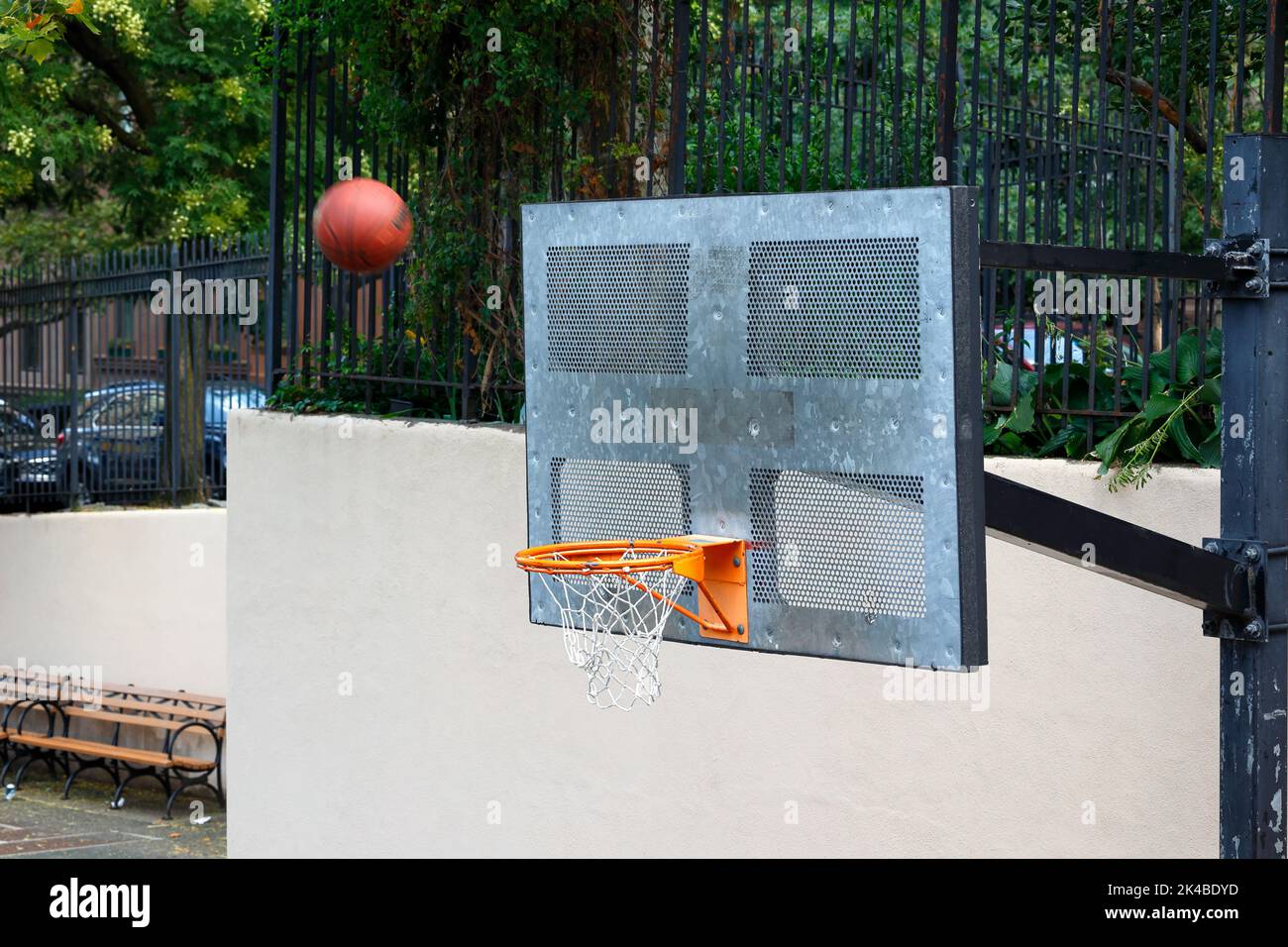 Ein Basketball, der durch die Luft in Richtung Backboard fliegt, mit einem unbekannten Ergebnis, ob er in den Reifen gehen wird. Stockfoto