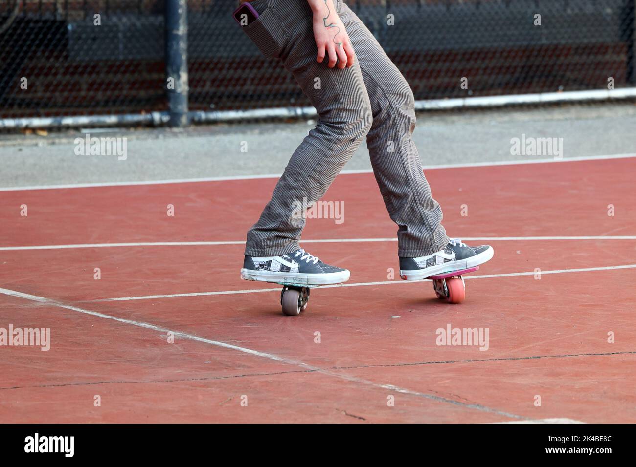 Eine Person mit Freeline Drift Skates Freeskaten auf einem Asphalt Spielplatz Stockfoto