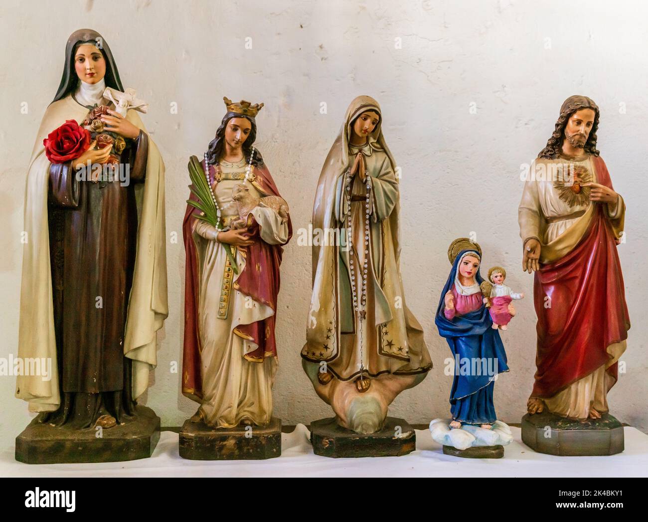 Fünf katholische Statuen, darunter eine von Jesus Christus und eine von der Jungfrau, heiraten mit ein paar Heiligen. Stockfoto