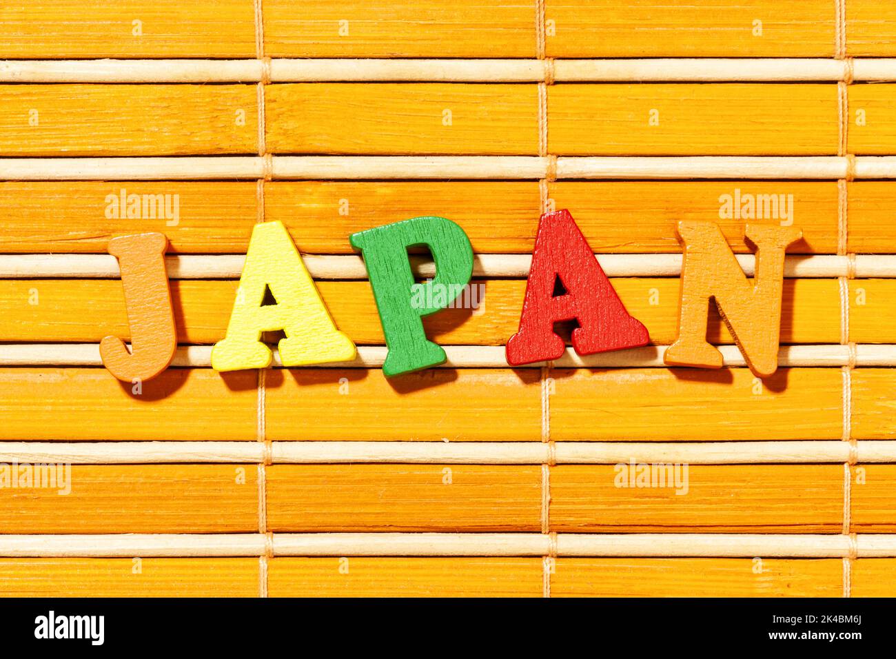 Japan Word - Beschriftung durch Farbbuchstaben auf Bambusmatte Stockfoto