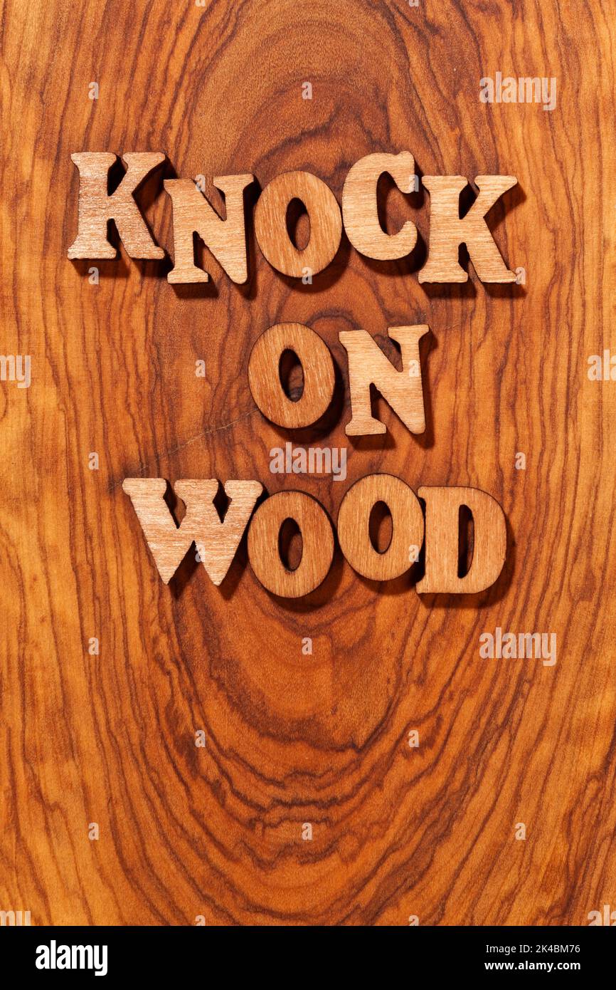 Klopfen Sie auf Holz Phrase durch Holzbuchstaben Nahaufnahme Stockfoto