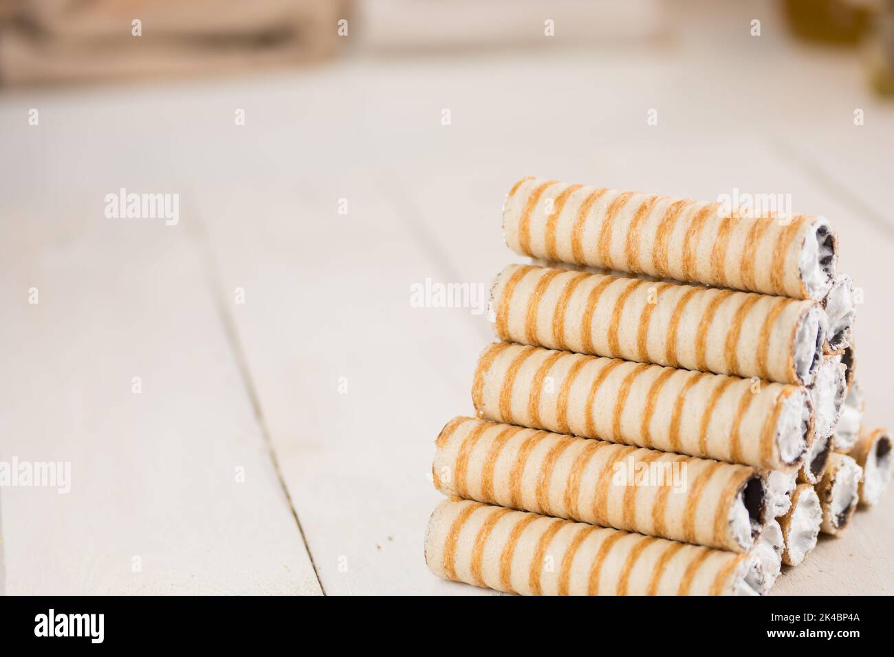 Kuchen genannt Rohr auf dem hölzernen weißen Tisch mit Kopieplatz für Text. Dessert gefüllt mit geschlagenem Eiweiß. Kuchen auf Hochzeiten serviert. Stockfoto