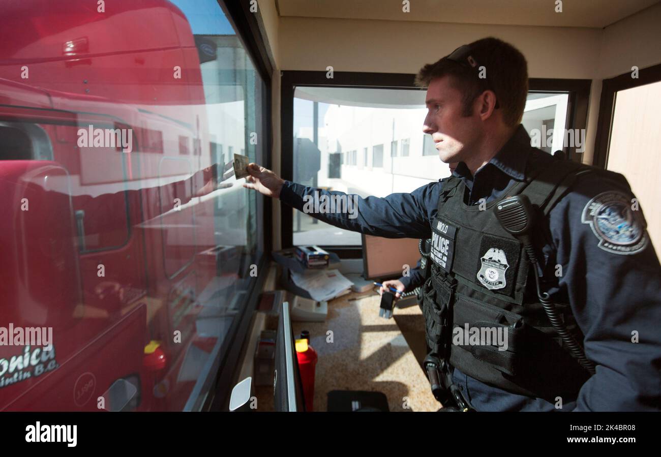 Ein US-Zoll- und Grenzschutzbeauftragter überprüft die Identifizierung des LKW-Fahrers, während er den US-Kontrollpunkt der Frachtvorinspektion im Hafen von Otay Mesa, Kalifornien, passiert, 23. Juni 2016. An jedem Tag stehen mehrere hundert Lastwagen auf der mexikanischen Seite der Grenze an, um importierte Produkte zu liefern, die auf die Überprüfung durch Zollbeamte warten. Eine wachsende Anzahl von Reedereien nutzt die Cargo Pre-Inspection von CBP, die vertrauenswürdigen Spediteuren eine schnellere und effizientere Möglichkeit bietet, Produkte an US-Einzelhändler zu liefern. CBP-Foto von Glenn Fawcet Stockfoto