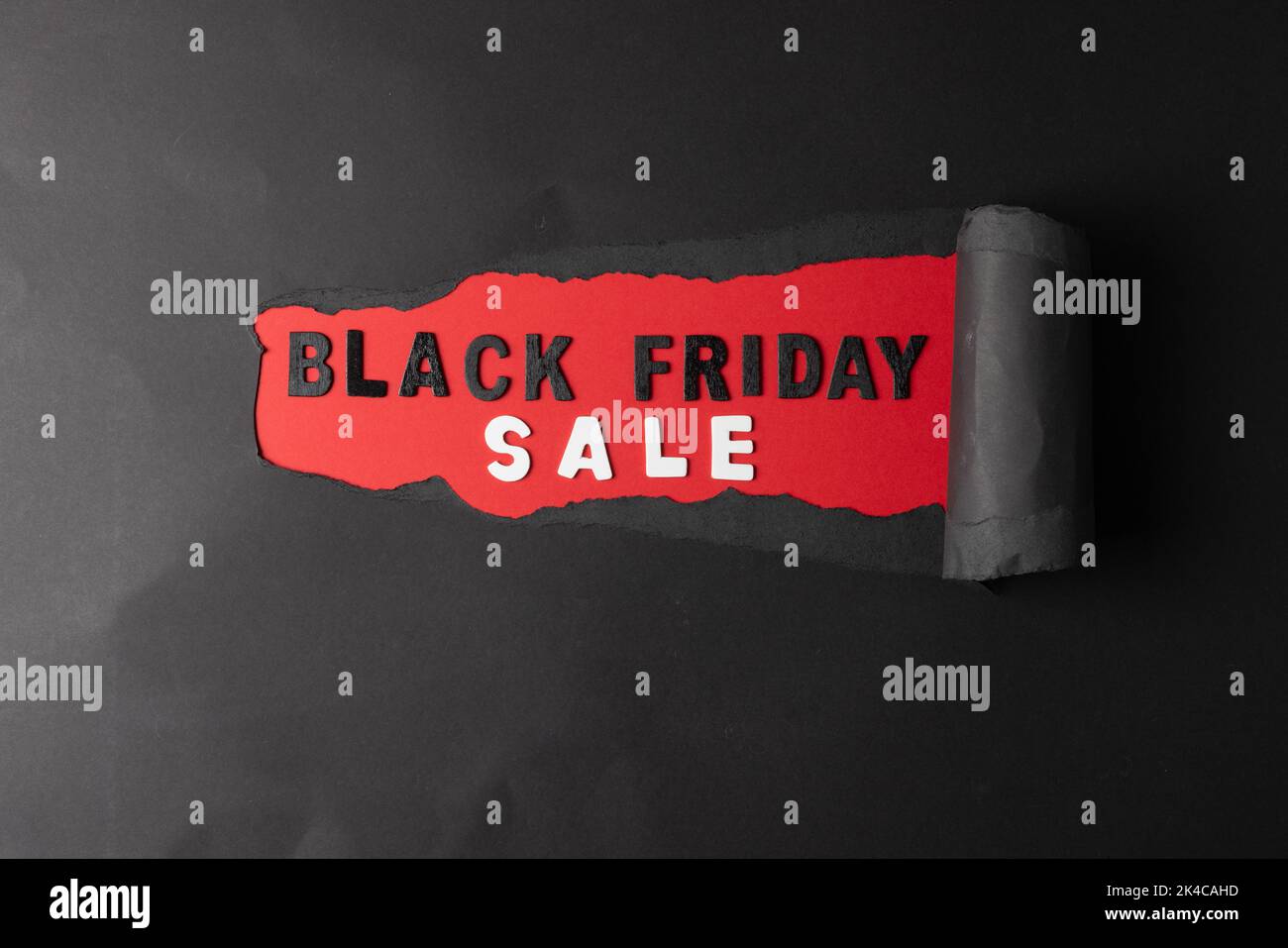 Komposition aus schwarzem Papier und schwarzem freitagsverkaufstext auf rotem Hintergrund Stockfoto