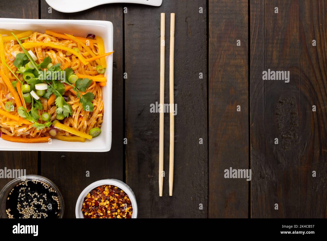 Blick von oben auf asiatische Wok rühren braten Nudeln mit Essstäbchen mit Kopie Platz auf Holz Stockfoto