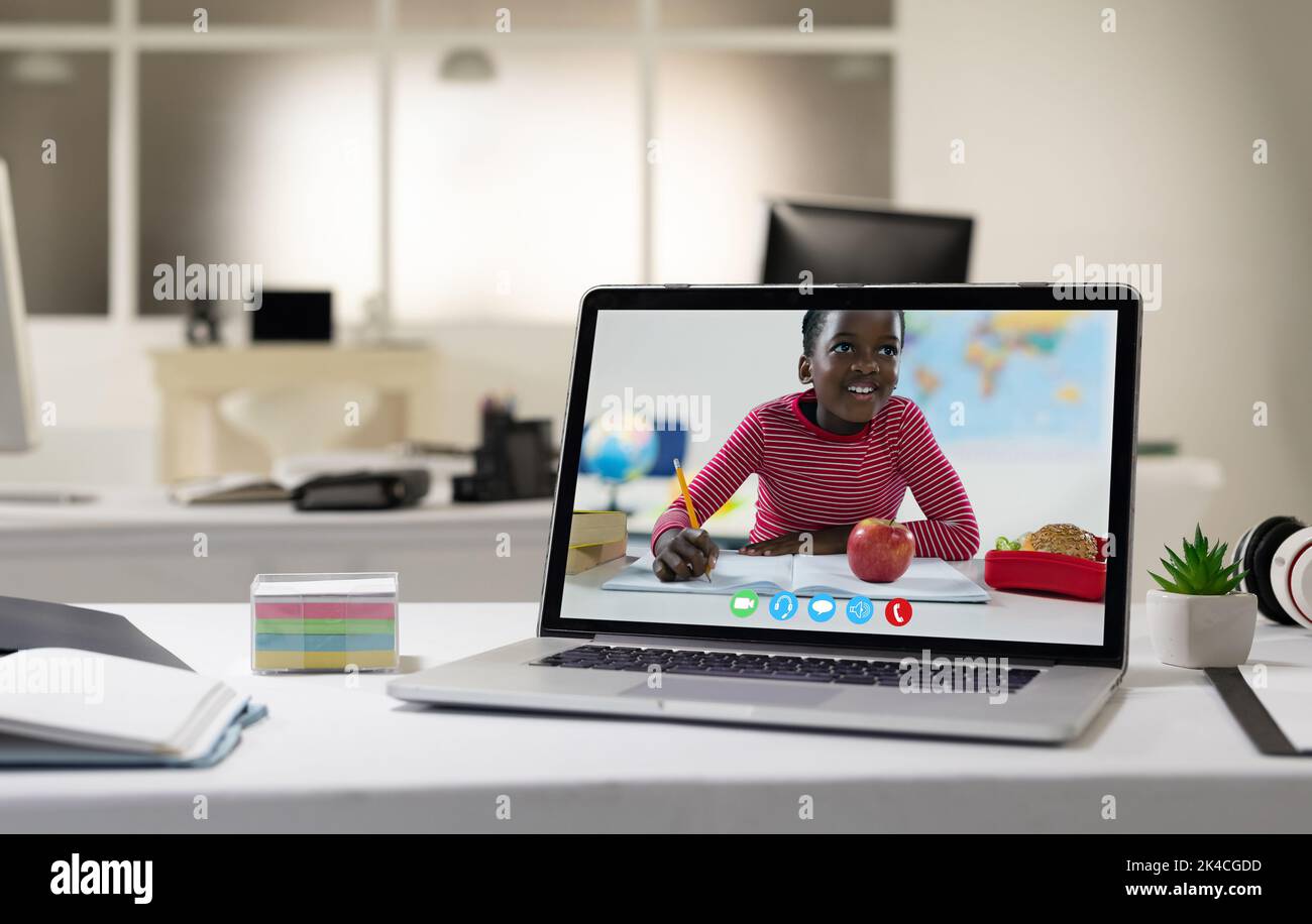 Laptop-Computer mit Videoanruf eines afroamerikanischen Jungen auf dem Schreibtisch. Arbeiten Sie in einem modernen Büro. Stockfoto