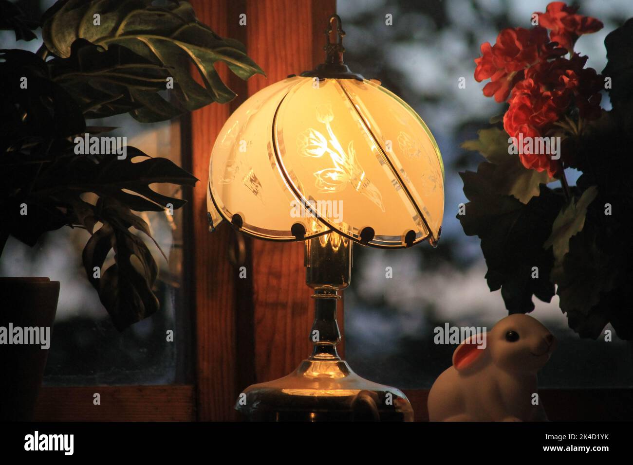 Eine Nahaufnahme einer dekorativ beleuchteten Vintage-Lampe auf einem Nachttisch Stockfoto
