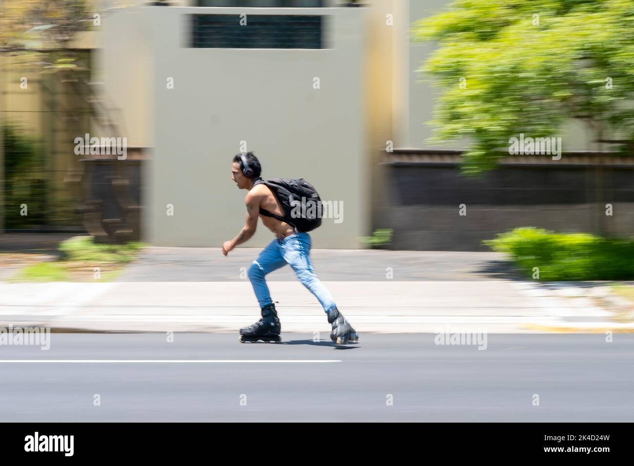 Junger Mann, Schlittschuhlaufen mit Schlittschuhen, Schlittschuhlaufen auf der Straße, verschwommener oder unscharfer Hintergrund, mexiko Stockfoto