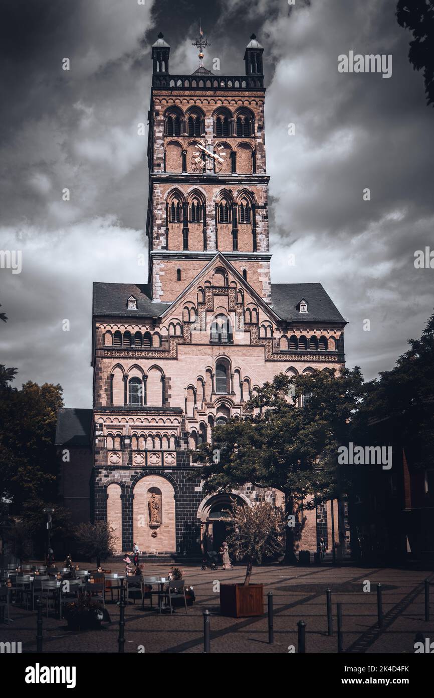 Eine vertikale Ansicht der Basilika St. Quirinus vor einem dramatischen Himmel in Neuss, Deutschland Stockfoto