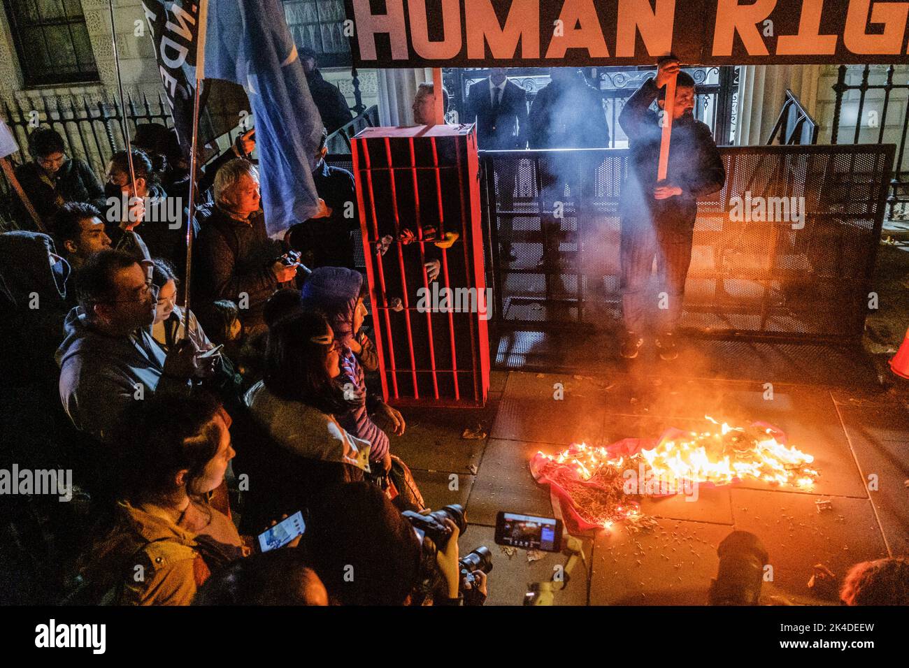 London, Großbritannien. 01. Oktober 2022. Während des Protestes gegen die Kommunistische Partei Chinas wird vor der chinesischen Botschaft die chinesische Nationalflagge in Brand gesetzt. Eine gemeinsame Kundgebung von Ukrainern, Hongkongers und Tibetian, die zum Protest „Widerstand gegen die KPCh“ am chinesischen Nationalfeiertag aufrief. (Foto von May James/SOPA Images/Sipa USA) Quelle: SIPA USA/Alamy Live News Stockfoto