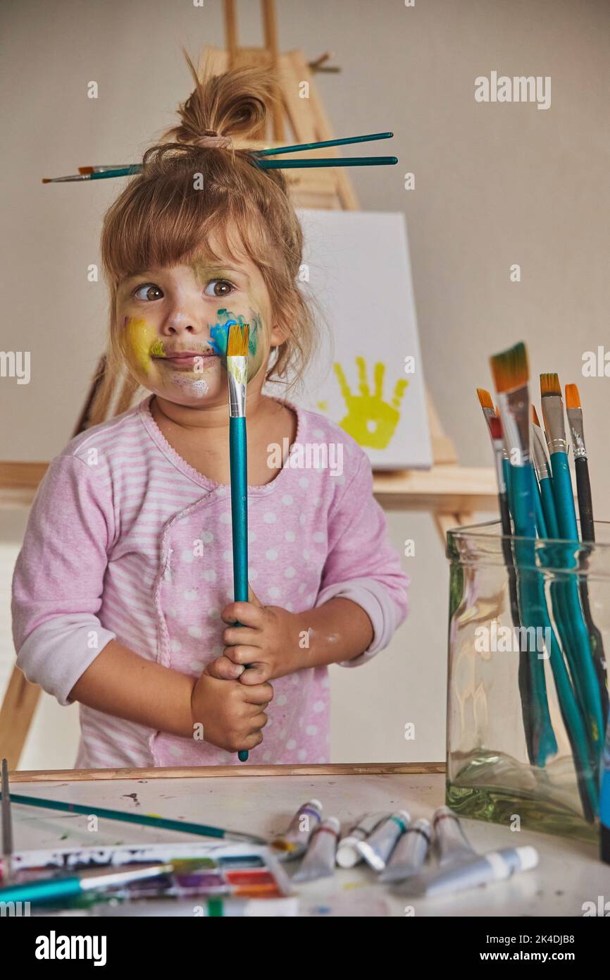 Charmantes Kind zeichnet und färbt alles mit Farben Stockfoto