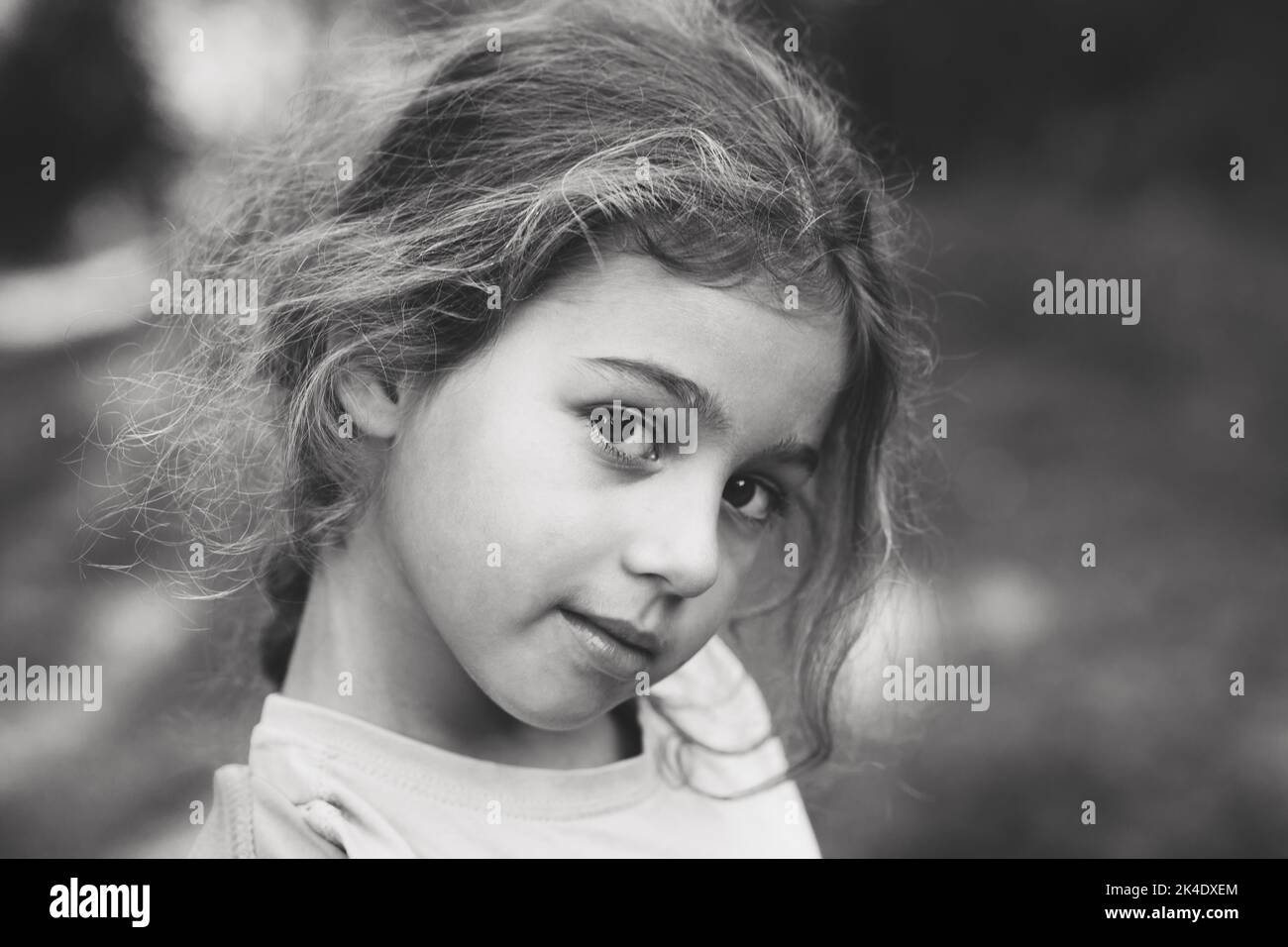 Schwarz und weiß Porträt von lächelnd niedlichen kleinen Mädchen im Sommer Park. Glückliches Kind, das die Kamera anschaut Stockfoto