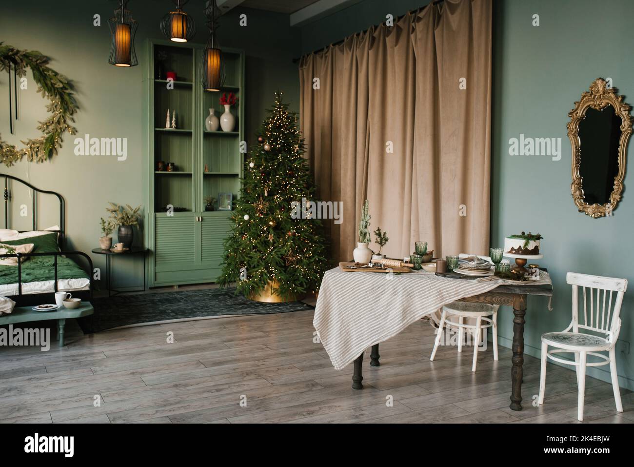 Festlicher Esstisch im Wohnzimmer vor dem Hintergrund der Weihnachtsbaumlichter Stockfoto