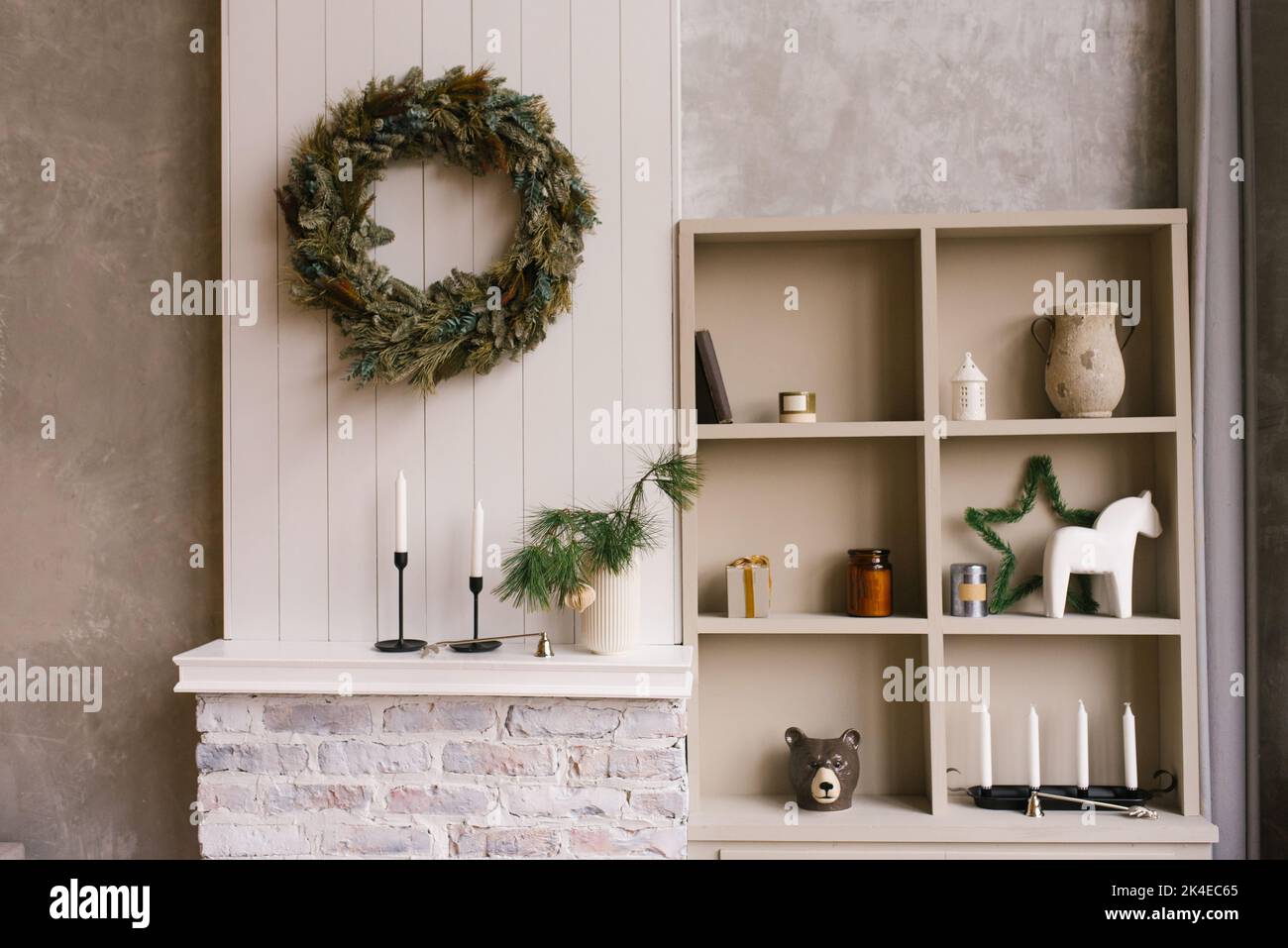 Weihnachtliche Einrichtung im Schlafzimmer oder Wohnzimmer mit Kleiderschrank mit offenen Regalen und Souvenirs sowie einem Kranz an der Wand Stockfoto