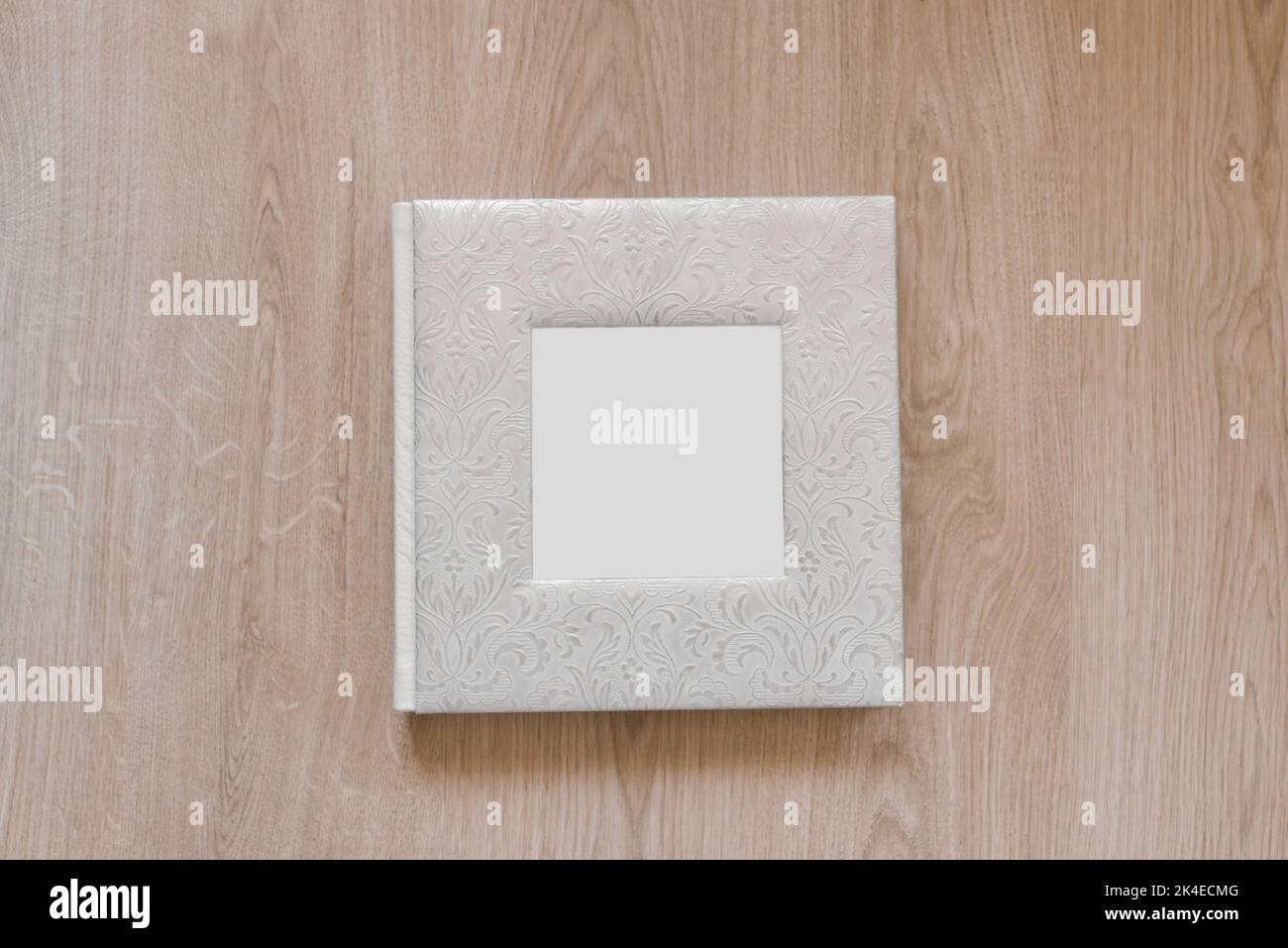 Hochzeitsfotoalbum oder Familienalbum in echtem Lederbezug auf Holzhintergrund. Flach liegend Stockfoto