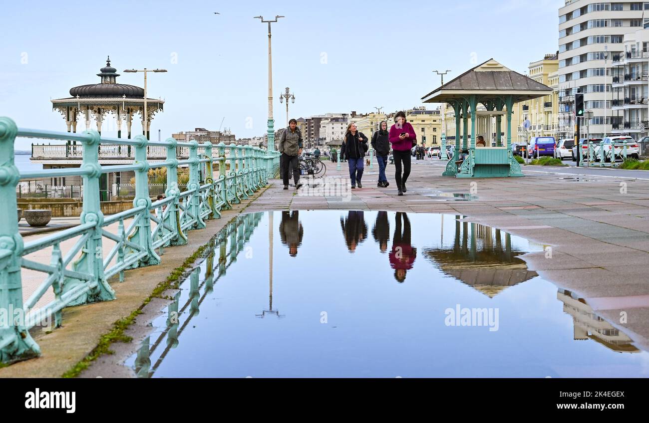 Brighton UK 2. October 2022 - Reflektionen in großen Pfützen an der Strandpromenade von Brighton nach starken Regenschauern, aber sonnigeren Bedingungen werden für den Rest des Tages prognostiziert. : Credit Simon Dack / Alamy Live News Stockfoto