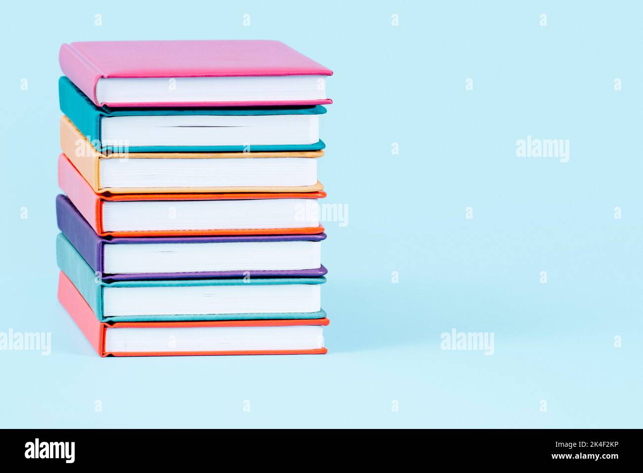 Stapel Bücher auf hellblauem Hintergrund. Vorderansicht, Platz für Text oder Produkt kopieren. Bildung, zurück zur Schule Konzept Stockfoto