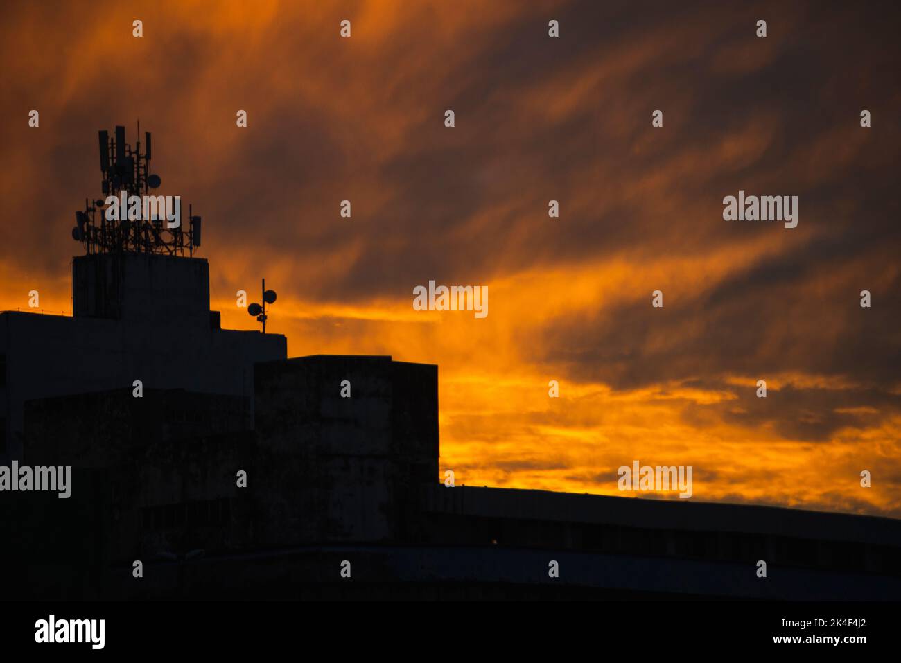 Gebäude Silhouette und TV-Antennen gegen orange farbigen dramatischen Sonnenuntergang. Schöner Spätnachmittag. Salvador, Bahia, Brasilien. Stockfoto