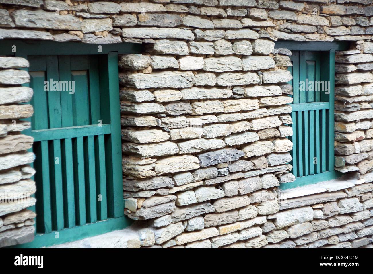 Holzfenster in einem traditionellen Steinhaus in Nepal Stockfoto