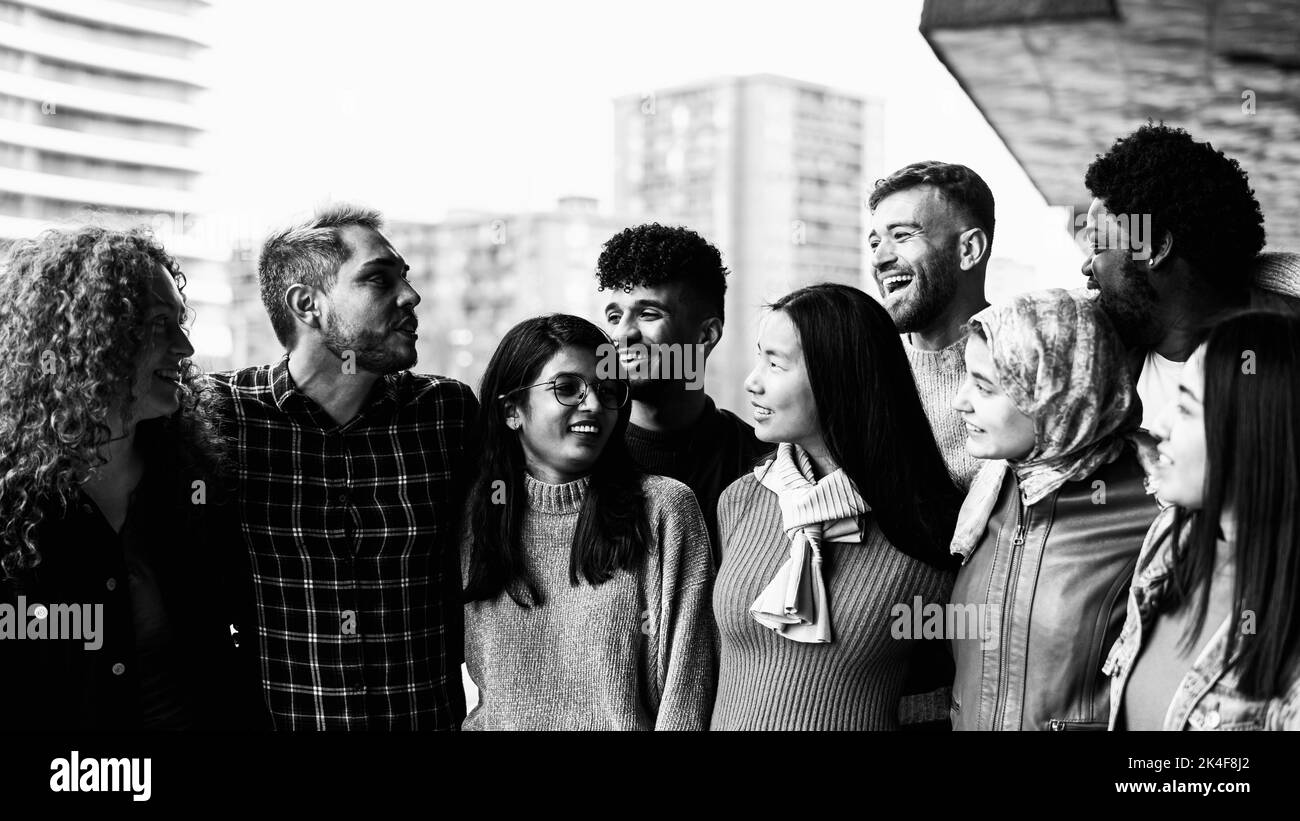 Junge multiethnische Freunde, die Spaß haben, gemeinsam in der Stadt zu hängen - Freundschafts- und Diversitätskonzept - Schwarz-Weiß-Schnitt Stockfoto