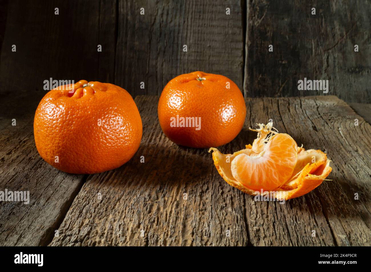 Zitrusfrüchte auf einem Holztisch. Essen auf dunklem Hintergrund. Süße Speisen für den Festtisch Stockfoto