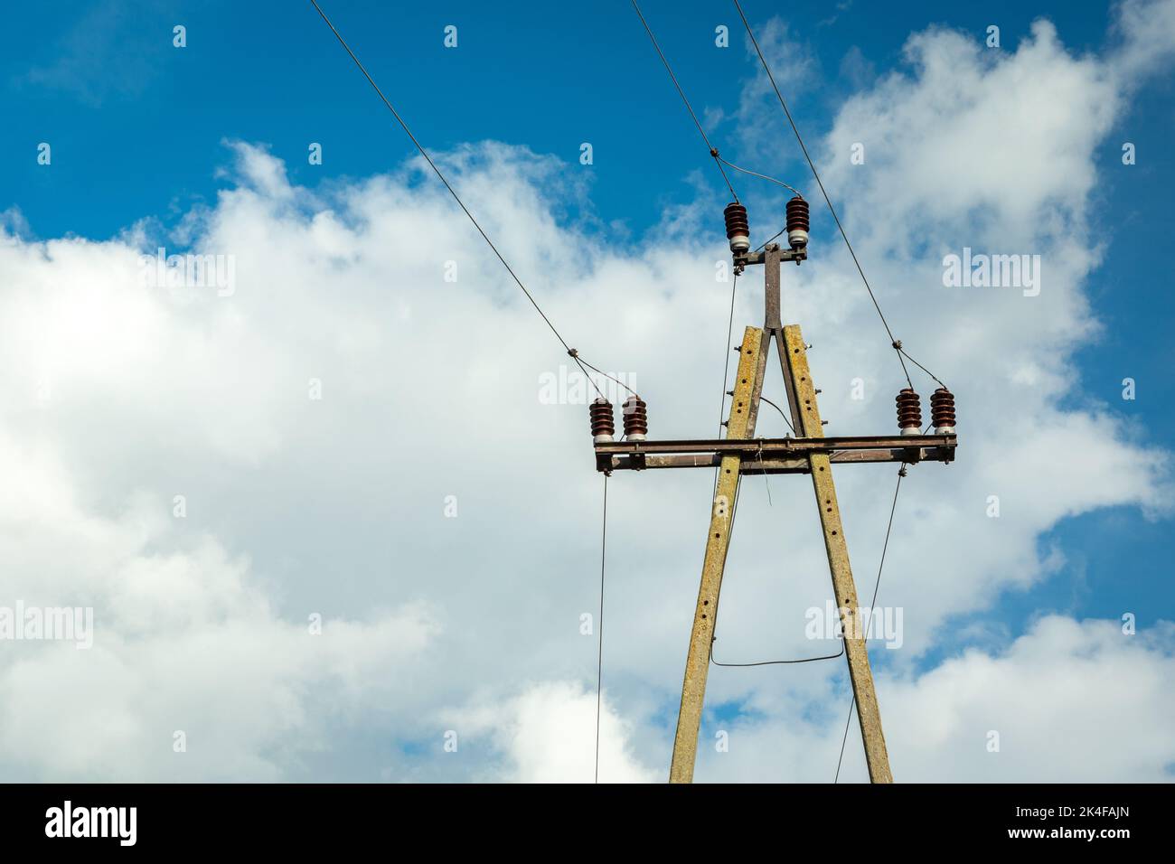 Einzelner elektrischer Betonmast mit Keramikisolatoren und Drähten Stockfoto