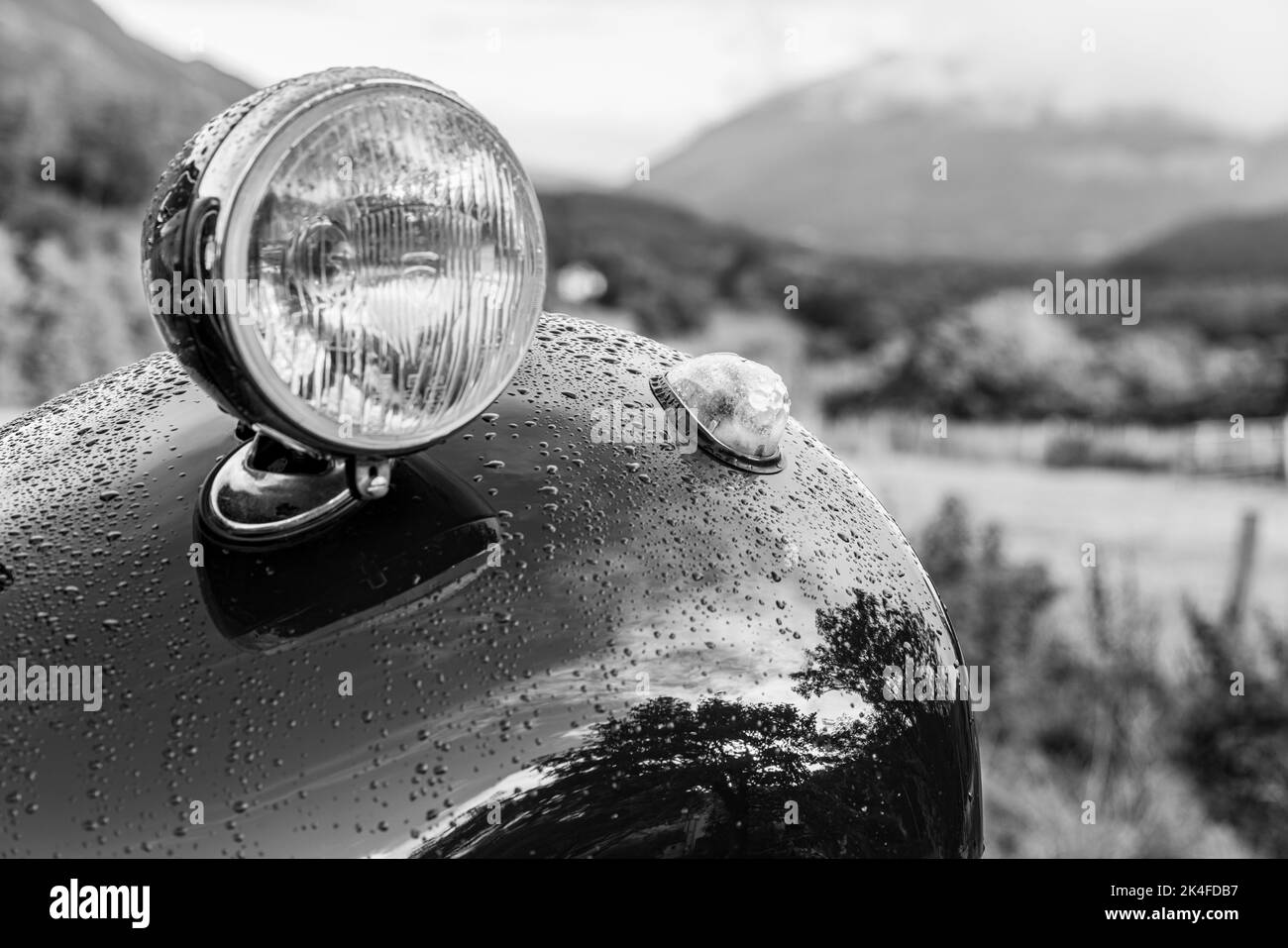 Reflexionen und Regentropfen auf der Lackierung des Kotflügelschutzes, der Karosserie und des Scheinwerfers eines Oldtimers des Autos des Autos des Autos des Autos des Autos des Autos des Autos des Autos des Autos des Autos des Autos des Autos des Jahres 15 im Lake District, Cumbria, eng Stockfoto