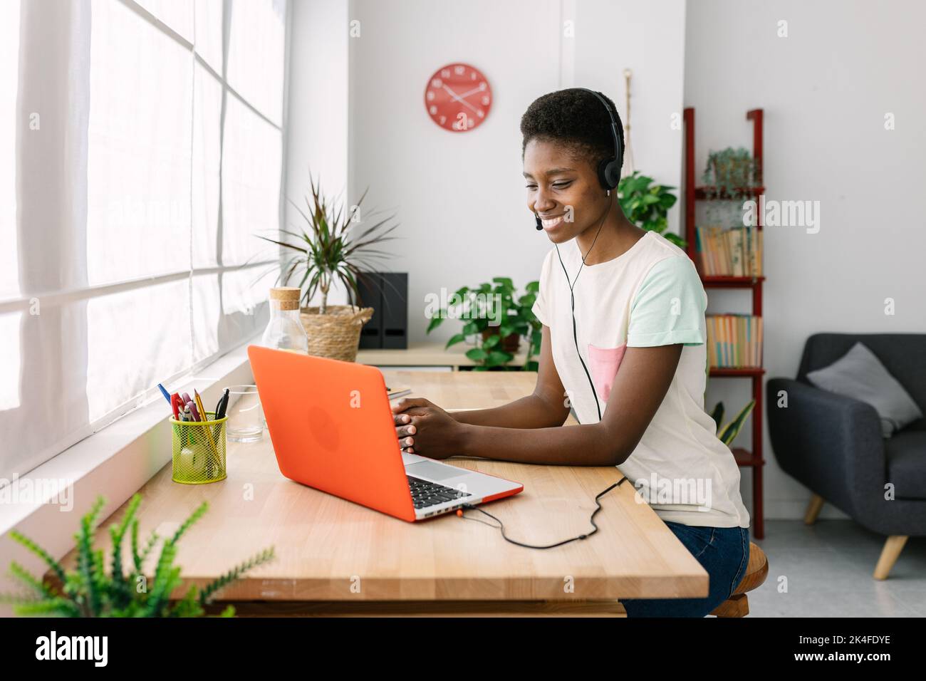 Junge afrikanerin mit Headset, die im Home Office arbeitet Stockfoto