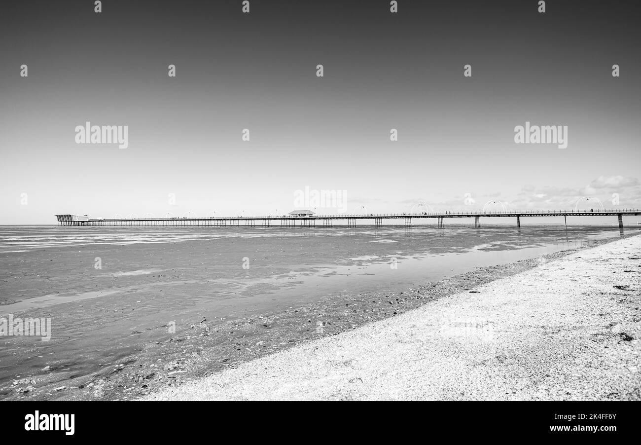 Ein Schwarz-Weiß-Bild des Southport-Piers, der bei Ebbe im Oktober 2022 in die Irische See ragt. Stockfoto