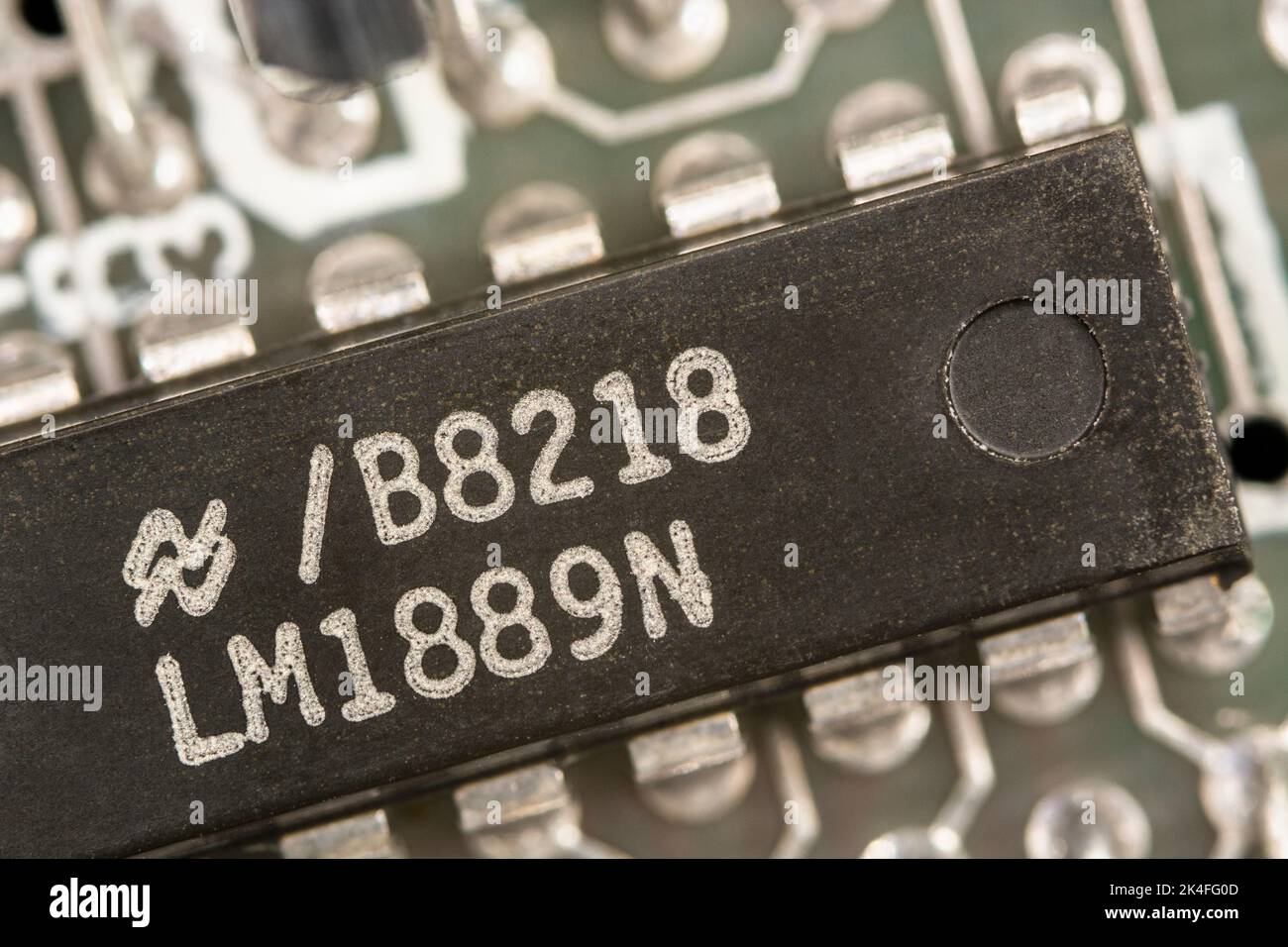 Kleine integrierte Schaltung/IC-Mikrochip-Pinbelegungen, die auf einer leiterplatte gelötet sind. Eigentlich ein 1982 Sinclair ZX Spectrum Computer. Die Komponente ist der TV-Videomodulatorchip Stockfoto