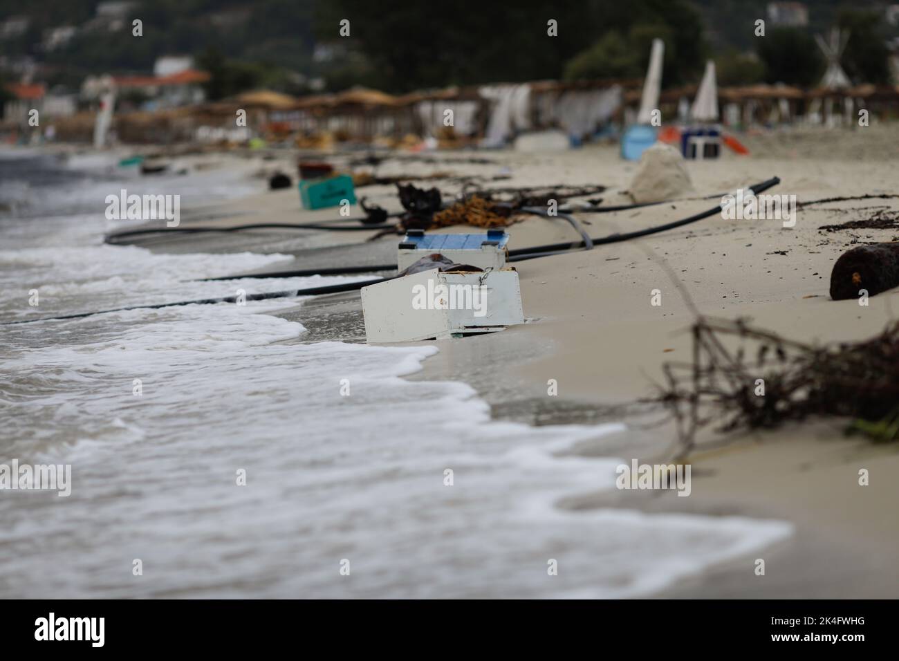 Holz, Plastik und sogar hölzerne Bienenstöcke wuschen nach einem starken Sturm an einem bewölkten Sommermorgen am Golden Beach in Thassos an Land. Stockfoto