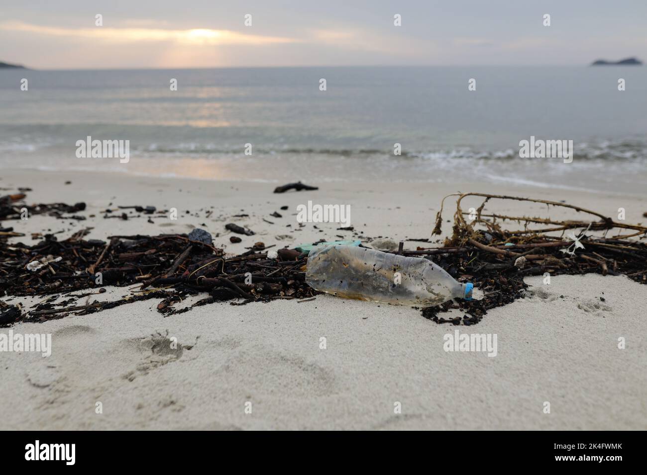 Plastik- und Holzabfälle wuschen nach einem starken Sturm an einem bewölkten Sommermorgen am Golden Beach in Thassos an Land. Stockfoto