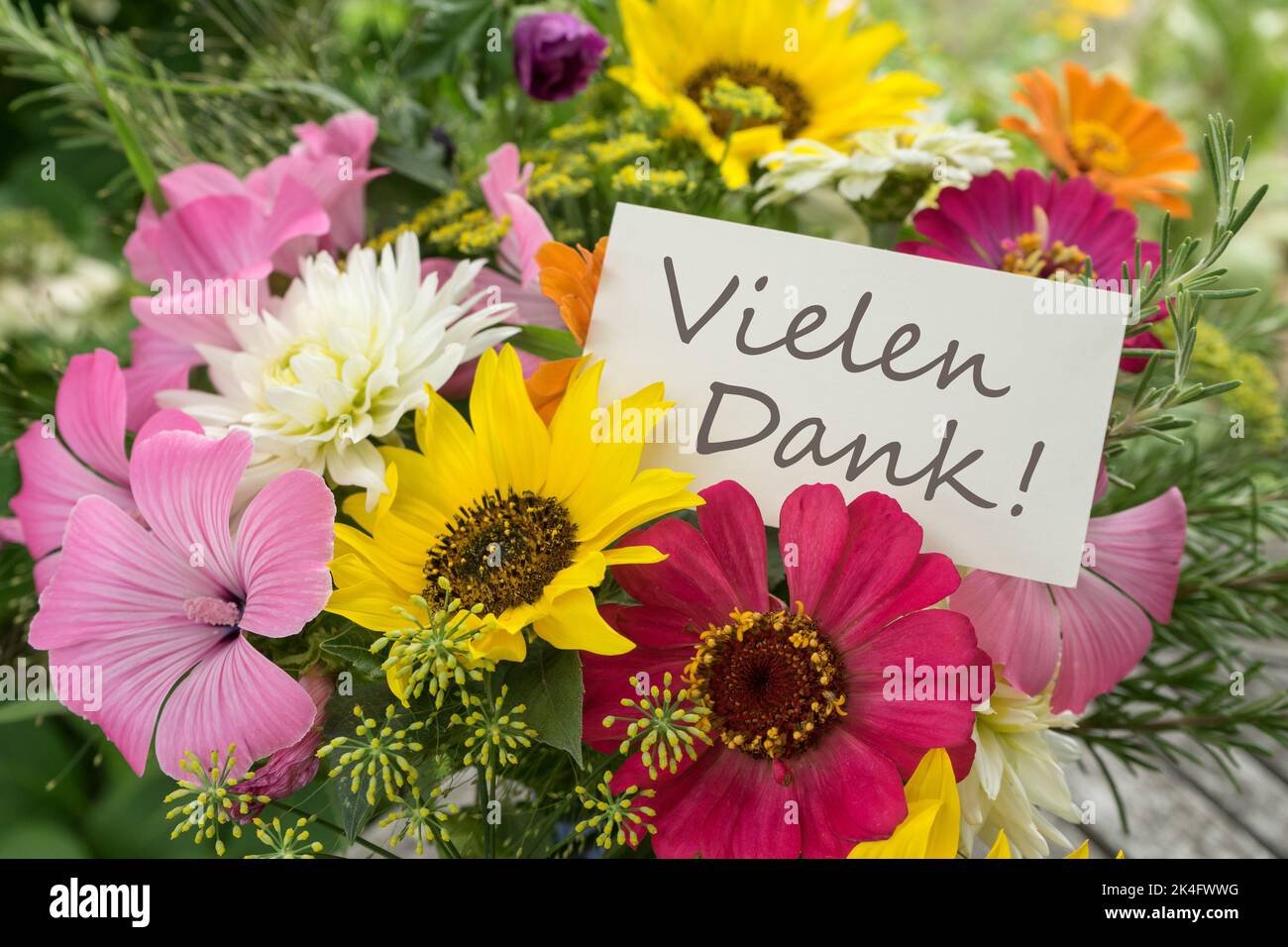 Farbenfroher Blumenstrauß mit Karte und deutschem Text: Vielen Dank Stockfoto