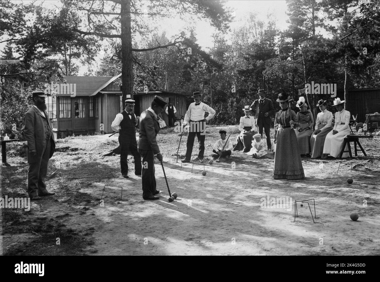 Männer und Frauen spielen den Absturz vor Häusern auf Lidingö. Nordisch Stockfoto