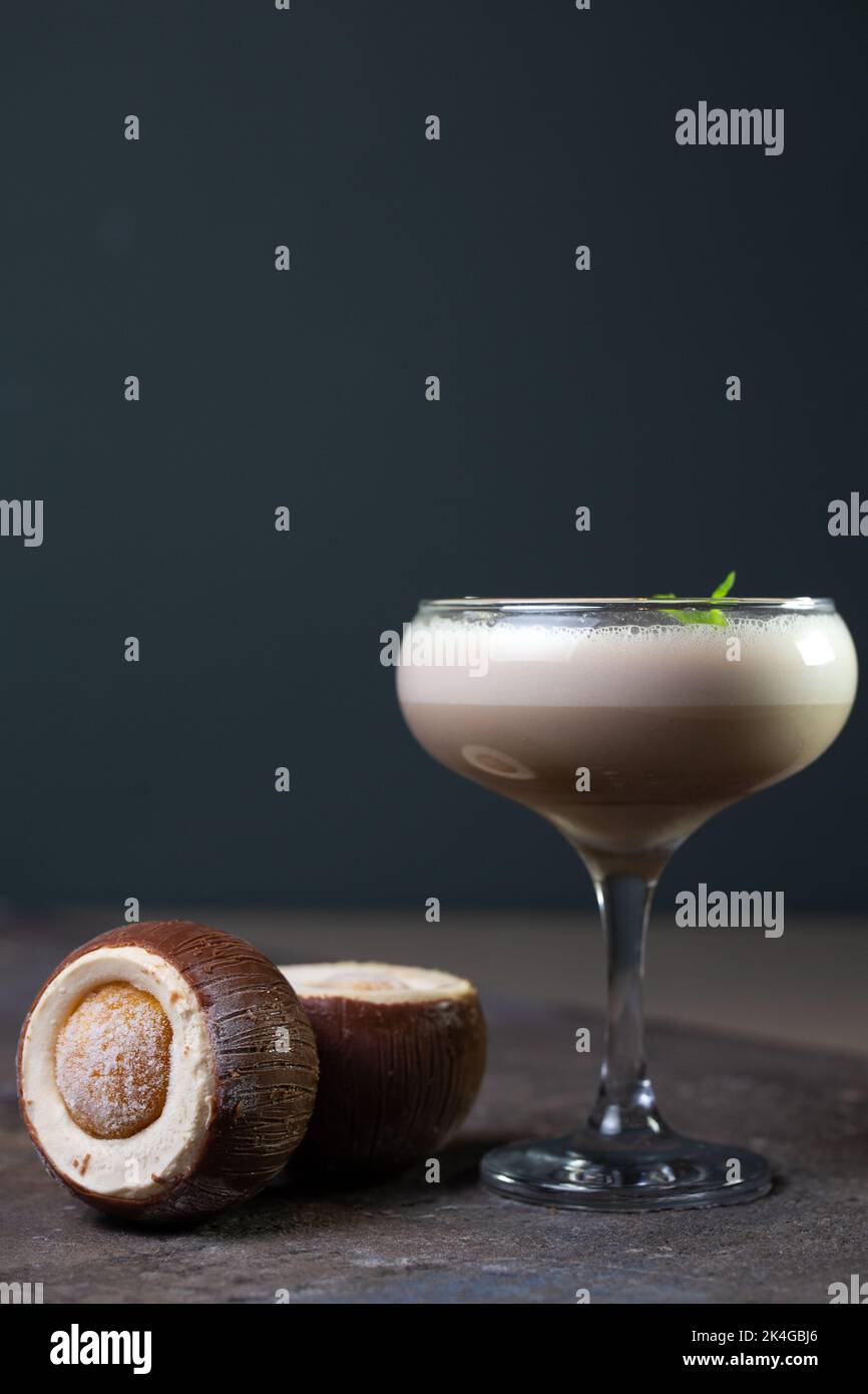 Cocktail und Kokosnuss-Dessert auf dunklem Hintergrund Stockfoto